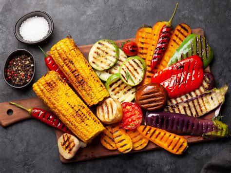 grillrácson sülő kolbászok és zöldségek
