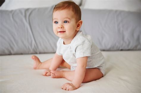 Baba ül egy etetőszékben és kóstolgatja a sárgarépapürét