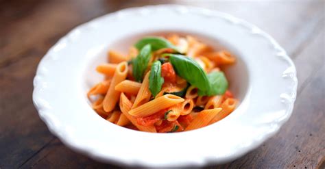 Penne all'Arrabbiata egy tányérban friss bazsalikommal