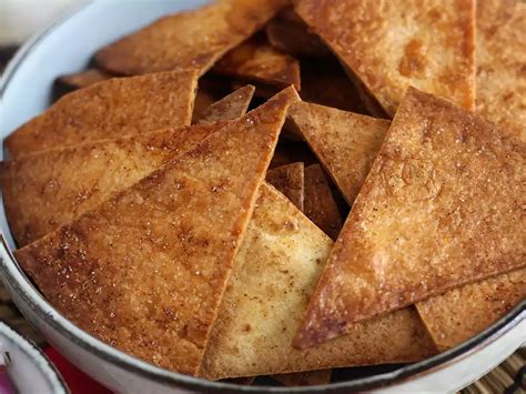 Különböző színű és textúrájú salsák tálkákban, mellette tortilla chipsek