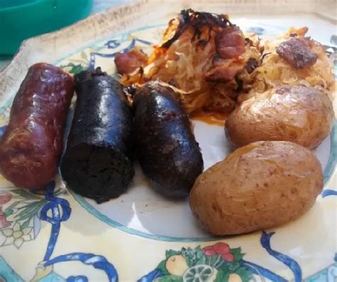 Savanyú káposztás hurka egy cserépedényben, köretként krumplival és kenyérrel