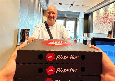 Mosolygó Pizza Hut alkalmazottak egy forgalmas pult mögött