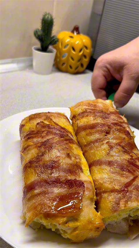 Összeszedett alapanyagok egy asztalon: csirkemell, bacon, reszelt sajt, tejszín, liszt, tojás, só, bors, szerecsendió, és egy cukkini