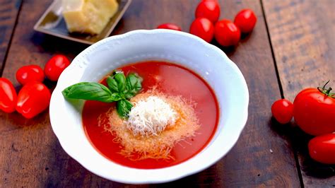 Tálban tálalt paradicsomleves friss bazsalikommal és egy gombóc mozzarellával