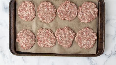 Various shapes of uncooked patties on a baking sheet