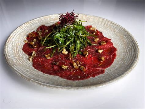 Tálra rendezett carpaccio rukkolával és dióval