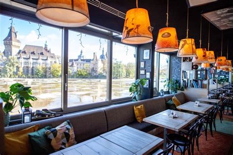 Étkezés élményszerű környezetben, panorámás étteremben, ahol a vendégek ínycsiklandó ételeket fogyasztanak.