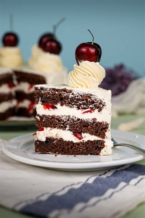 A perfectly sliced Black Forest cake showing the distinct layers of cream, cherry, and chocolate sponge