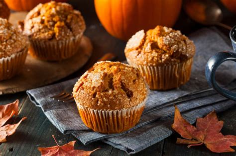 Sütőtökös muffinok egy rusztikus fa asztalon, őszi dekorációval