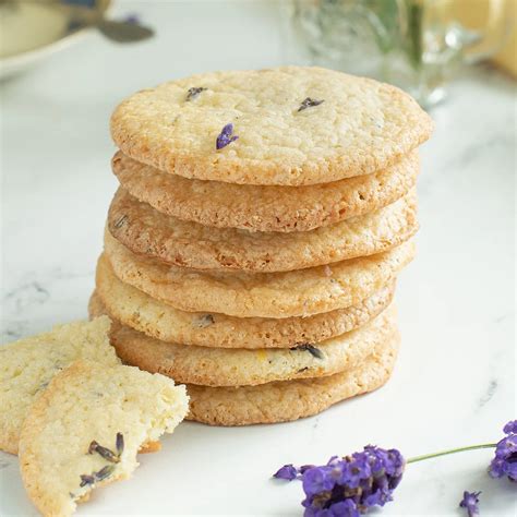 Different shapes of pressed lavender cookies on a cooling rack