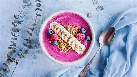 Smoothie bowl színes gyümölcsökkel, magvakkal és granolával díszítve egy tálban
