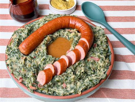 Hagyományos holland ételek, mint a Stamppot és a Rookworst tányérban