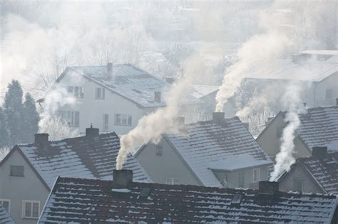Füstölő kémény egy ház tetején télen