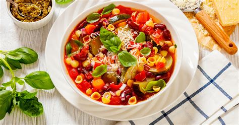 A minestrone leves egy nagy tálban, friss zöldségekkel és parmezánnal