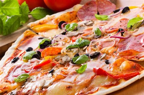 három különféle feltétekkel gazdagított pizza a sütőben