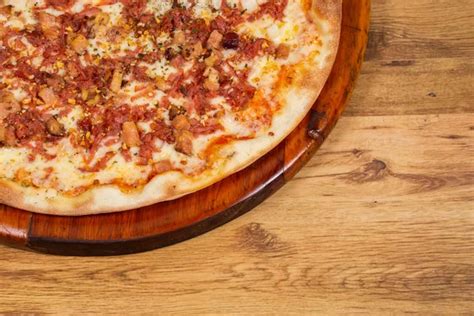 frissen sült, gőzölgő magyaros pizza egy fából készült asztalon