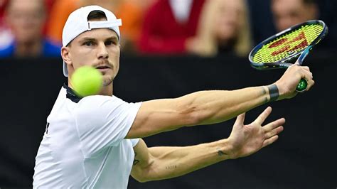 Young Márton Fucsovics holding a junior tennis trophy