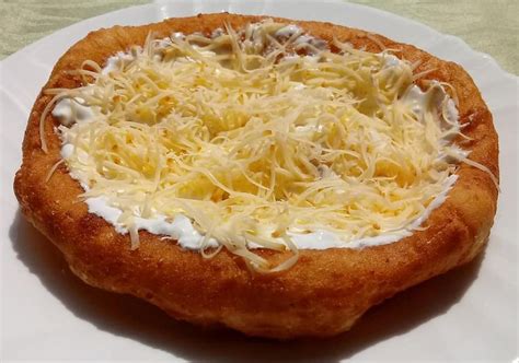 Lángos tányéron, tejföllel és sajttal