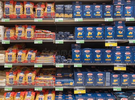 Supermarket aisle with various pasta brands and prices