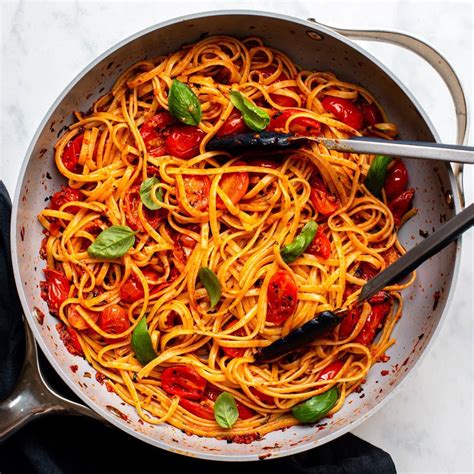 A bowl of spaghetti with tomato sauce and basil