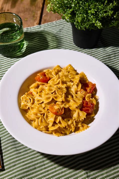 Tányér paradicsomos-ricottás cukkinis farfalle tésztával, friss bazsalikommal és reszelt parmezánnal
