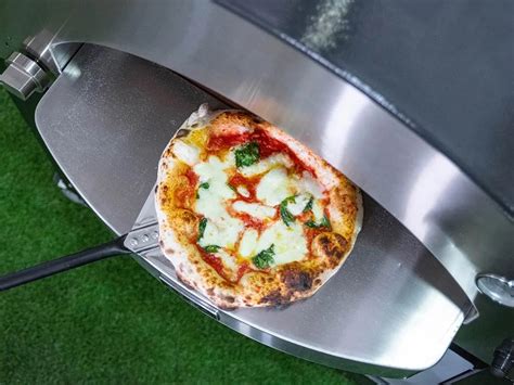 Pizza lapátok és pizzaszeletelők egy pizzasütő mellett
