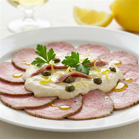 Tányéron lévő vékonyra szeletelt marhanyelv gremolatával