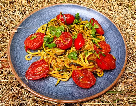 Cukkini spagetti tányéron, friss paradicsommal és bazsalikommal