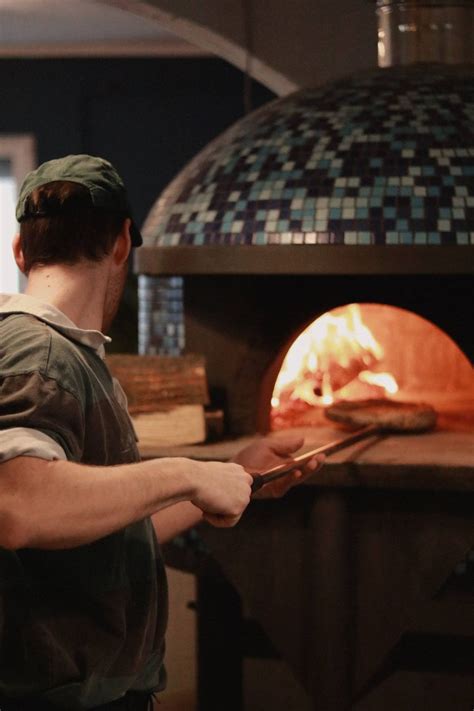 Hagyományos fatüzelésű kemencében készülő olasz pizza látványa