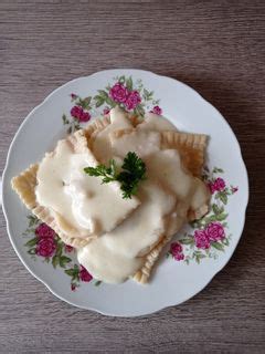 Tányér frissen tálalt ravioli sajtmártással és petrezselyemmel