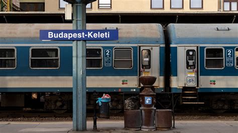 Kávé és gyorsétel egy utazó kezében a pályaudvar közelében